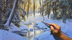 a person is painting a snowy scene in the woods with water and trees, while holding a paintbrush