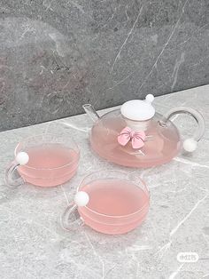 three pink tea cups and saucers sitting on a marble table