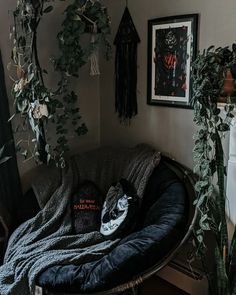 there is a black cat sleeping on the couch in this room with plants and pictures