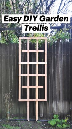 a wooden trellis sitting in the middle of a yard next to a fence and trees