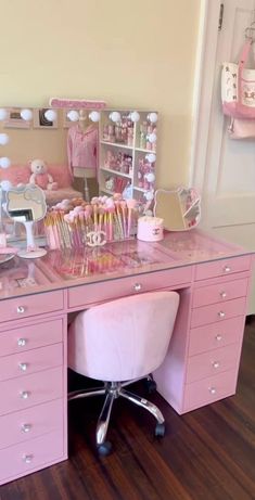 a pink desk with lots of cupcakes and other items on top of it