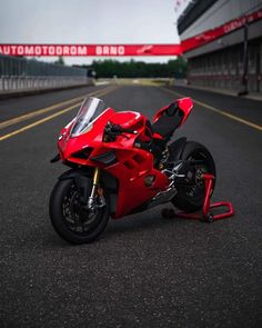 a red motorcycle parked on the side of a road