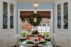 a dining room table decorated for christmas with wreath