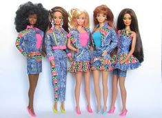 five barbie dolls standing next to each other in front of a white wall with the same outfit on