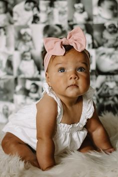 a baby girl with a pink bow on her head