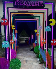 the entrance to an arcade decorated with neon lights and paper fish decorations in front of it