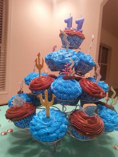 cupcakes in the shape of boats and anchors on top of a cake stand