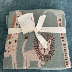 a blue blanket with giraffes on it and a white ribbon tied around the edge