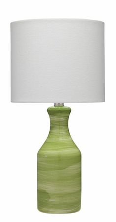 a green lamp with a white shade on it