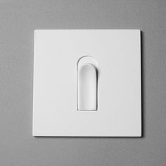 a white light switch sitting on top of a gray wall