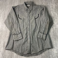 Vintage 80s Ranch Wear Western Cowboy Stitched Embroidered Pearl Snap Streetwear Grey Button Up Collar Shirt Double Extra Large Mens Condition: Fair Used Condition = Has flaws on the sleeve due to wear and age. Measurements: Please see photos above for all measurements IF YOU BUY TWO OR MORE ITEMS USE THE CODE BUNDLE @ CHECK TO SAVE 20% WE SHIP WITHIN 24 HOURS AFTER PURCHASE! Please be aware that we do not offer free returns!! The Buyer is responsible for the cost of the return label.  Follow us on TikTok & Instagram @findsnostalgic and tag us in your finds Western Long Sleeve Shirt With Buttons, Western Style Long Sleeve Shirt With Buttons, Embroidered Button-up Western Tops, Western Style Embroidered Button-up Top, Western Long Sleeve Embroidered Shirt, Western Style Long Sleeve Embroidered Shirt, Vintage Embroidered Button-up Shirt, Classic Embroidered Button-up Shirt, Western Long Sleeve Top With Floral Embroidery