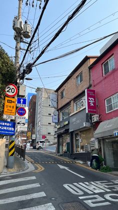 an empty street with lots of signs on the sides and buildings in the back ground