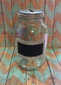 a glass jar with a black label on it sitting on top of a wooden table