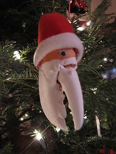 an ornament hanging from a christmas tree in the shape of santa's head