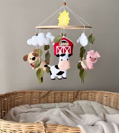 a baby crib with several farm animals hanging from it