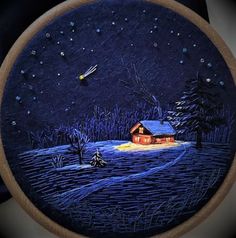 a hand embroidered picture of a cabin in the woods at night with snow falling on the ground