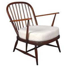 a wooden chair with a white cushion on the seat and armrests is shown