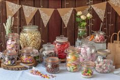 a table topped with lots of jars filled with candy