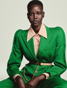 a woman in a green suit sitting down