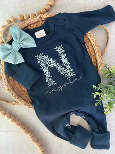 This features a soft navy romper with a large floral embroidered letter and name in a soft seafoam mint in the name of your choice, and an option for a matching bow or turban. This outfit makes a perfect coming home outfit, newborn pictures, or baby shower gift.  This romper has cute little footies that fold over the feet, and has fold over mittens for tiny hands. It has snaps around legs for easy changing access.  Preemie 5-7lbs Newborn fits approximately 6-9lbs 0/3 fits approximately 9-14lbs 3 Personalized Cotton Onesie For Loungewear, Baby Girl Outfits Newborn Winter Coming Home, Newborn Homecoming Outfit, Personalized Fitted Onesie For Spring, Girl Going Home Outfit, Embroidered Newborn Outfit, Spring Cotton Onesie With Name Print, Navy Romper, Monogrammed Baby Gown