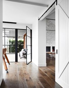 an open door leading to a living room with wood floors and white walls in the background