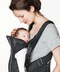 a woman holding a baby in a sling