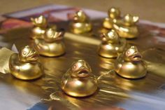 several gold rubber ducks sitting on top of a table