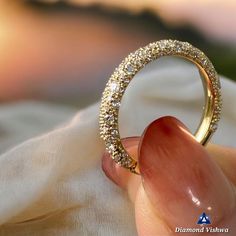 a close up of a person's hand holding an open ring with diamonds on it