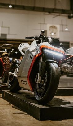 an orange and white motorcycle on display in a building