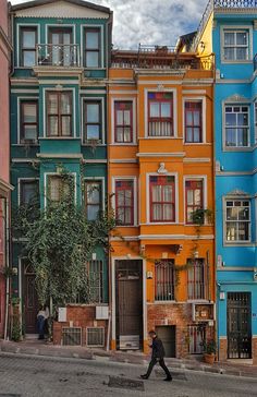 a person walking down the street in front of colorful buildings