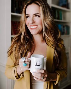 a woman holding a coffee mug in her right hand