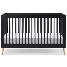 a black crib with white sheets and wood trims on the bottom, in front of a white background