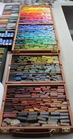 many different colored pencils are lined up on a table