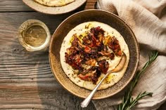 two bowls filled with food on top of a wooden table