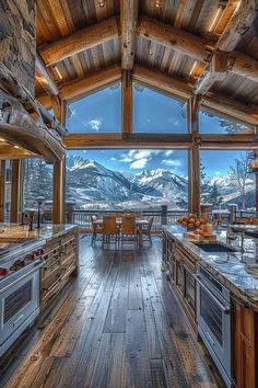 an open kitchen with wooden floors and mountain view