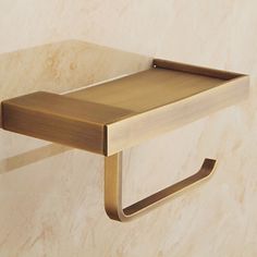 a bathroom shelf with a towel ring on the wall next to it and marble walls behind it