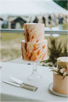 a three layer cake sitting on top of a table next to a knife and fork