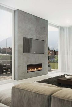 a modern living room with a fireplace and large glass doors that open to the outside