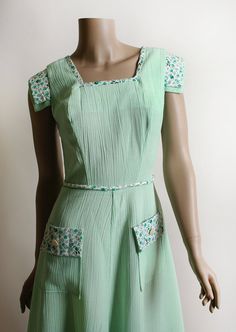 "FREE DOMESTIC SHIPPING! <3 ♥ Lovely vintage 1970s mint green cotton dress, with floral accents! ♥ Buttons up the back! Fitted waist, with matching floral waist tie rope. ♥ Cap style sleeves, with floral flap accent. Matching trim on the front skirt pockets! ♥ Cotton, crepe textured. Semi-sheer, you'll probably want a slip under. ♥ In great condition! * measurements when flat * Bust - 19\" across Shoulders - 14\" across Waist - 13\" across Hips - 21\" across Bodice length - 16\" Length - 40\" Green Lined Vintage Dress, Green Lined Vintage Dress For Summer, Green Lined Vintage Summer Dress, Green Retro Vintage Dress, Green Vintage Style Dress For Summer, Green Vintage Dress For Summer, Vintage Green Square Neck Dress, Retro Green Square Neck Dress, 1950s Green Short-sleeved Dress