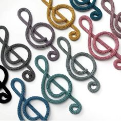 several different colored cords are lined up on a white surface, with one knot in the middle