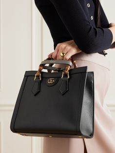 Gucci's 'Diana' tote was first introduced in 1991 and has since become an iconic style. Made from textured-leather, it's distinguished by its square shape, bamboo top handles - a house signature since 1947 - and 'GG' gold-tone hardware. It comes with two detachable straps that can be worn on your shoulder or cross-body. Iconic Designer Bags, Gucci Top Handle Shoulder Bag For Work, Gucci Calf Leather Shopping Bag, Chic Gucci Textured Leather Shoulder Bag, Gucci Calf Leather Tote Bag, Gucci Evening Bag In Calf Leather, Gucci Calf Leather Bags With Gold-tone Hardware, Gucci Bags With Gold-tone Hardware For Work, Gucci Calf Leather Evening Bag