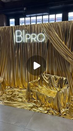 an image of a stage set up with gold cloth draped over it and the words biro