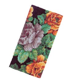 a cross stitch bookmark with flowers and leaves on the front, in green and orange colors