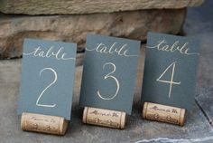 three wine cork place cards are sitting on the ground