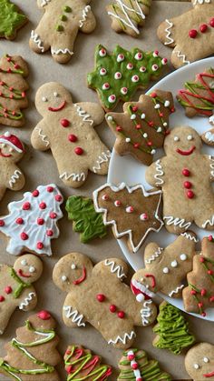 many different decorated cookies on a white plate and some green, red and white decorations