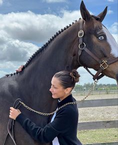 a woman standing next to a brown horse