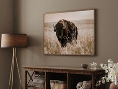 a bison is standing in the grass near a table with baskets and flowers on it