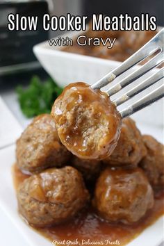 slow cooker meatballs with gravy on a white plate, being held by a fork