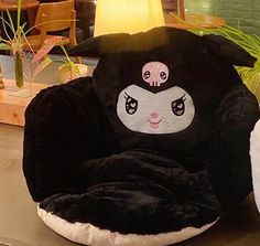 a black and white dog bed sitting on top of a table next to a potted plant