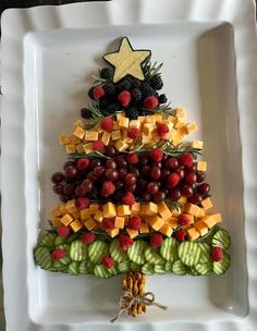 a christmas tree made out of fruits and vegetables on a white plate with a star